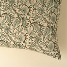 Decorative pillow with green floral pattern on beige background