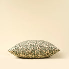 Decorative pillow with green leaf pattern on a beige background