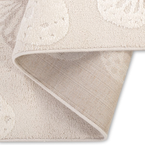 Folded edge detail of the Flutterby Meadow Kids Rug showing its bound edge and woven backing.