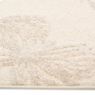 Close-up corner detail of the Flutterby Meadow Kids Rug showing its soft ivory pile.