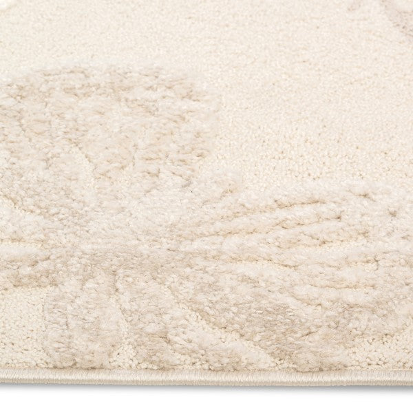 Close-up corner detail of the Flutterby Meadow Kids Rug showing its soft ivory pile.