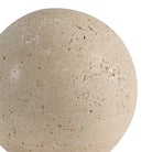 Extreme close-up of the Geo travertine decorative sphere, highlighting the natural beige color and porous stone texture.