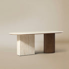 Gianna dining table with oval natural travertine top and dual wood pedestal base on beige studio background