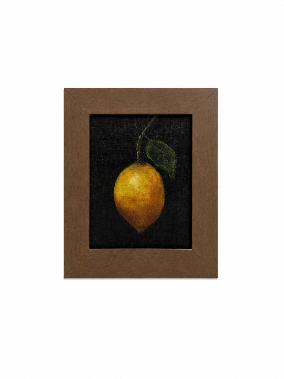 Framed artwork of a lemon with a leaf on a dark background