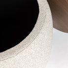 Macro close-up of the Haven Storage Ottoman showing the high-quality, nubby cream bouclé upholstery and the edge of the wood lid.
