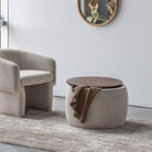The Haven Storage Ottoman styled as a coffee table next to a bouclé lounge chair on a textured neutral rug.