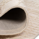 Rolled edge of the Hayes cream grid rug showcasing its soft textured top pile and durable woven backing