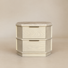 [Hexley White Oak & Travertine Nightstand] Front view showing the natural yellow travertine top, white oak body, two drawers, brass handles, and chamfered corners.