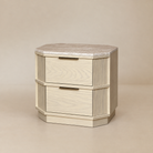 [Hexley White Oak & Travertine Nightstand] Three-quarter front view showing the two drawers, brass handles, chamfered corners, and natural yellow travertine top.