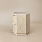 [Hexley White Oak & Travertine Nightstand] Side view showing the white oak grain, chamfered profile, travertine top, and recessed plinth base.
