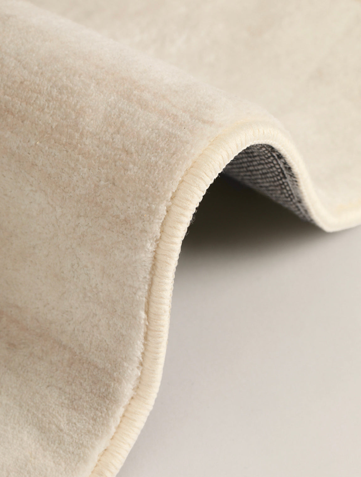 Close-up of the Isabella Rug showing its soft cream pile and finished edge