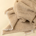 Beige textured blanket on a beige background