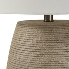 Close-up of a textured lamp base with a neutral lampshade.