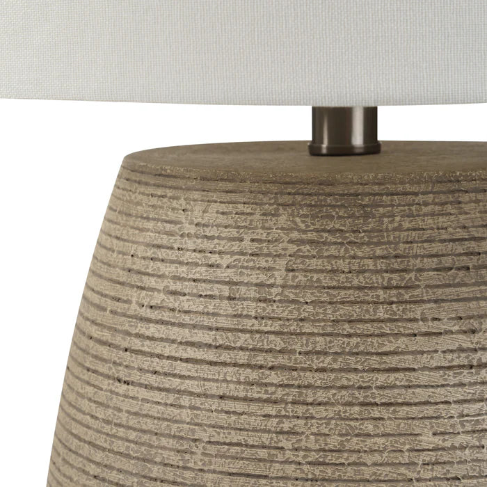 Close-up of a textured lamp base with a neutral lampshade.