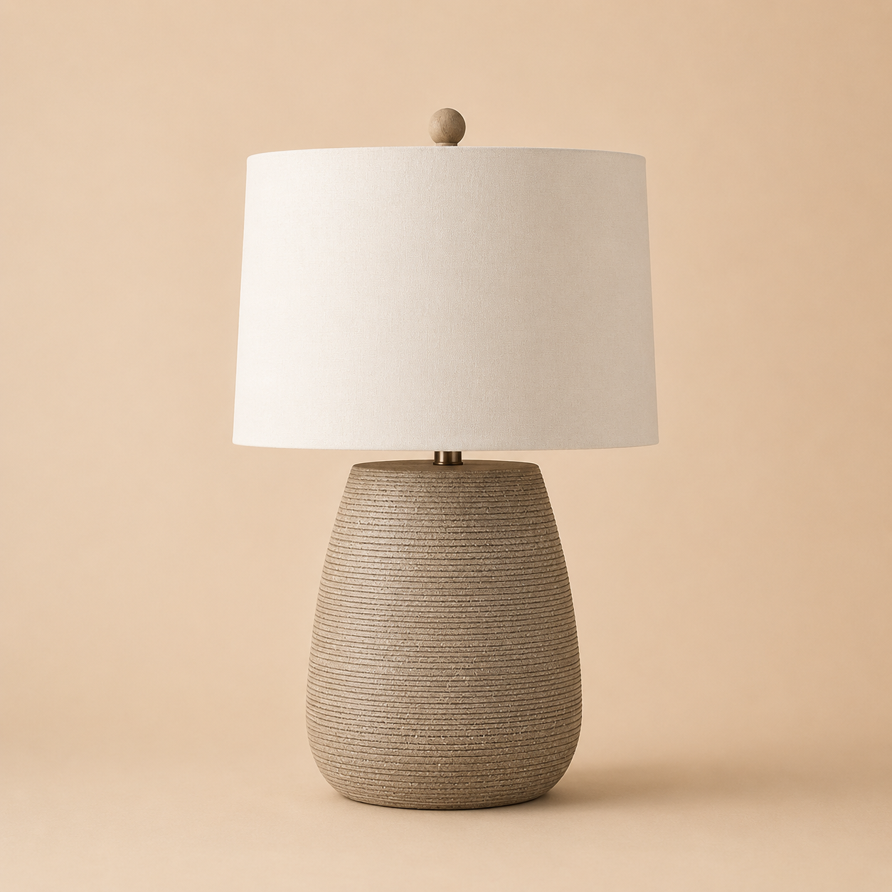 Table lamp with textured resin base and white shade on a beige background