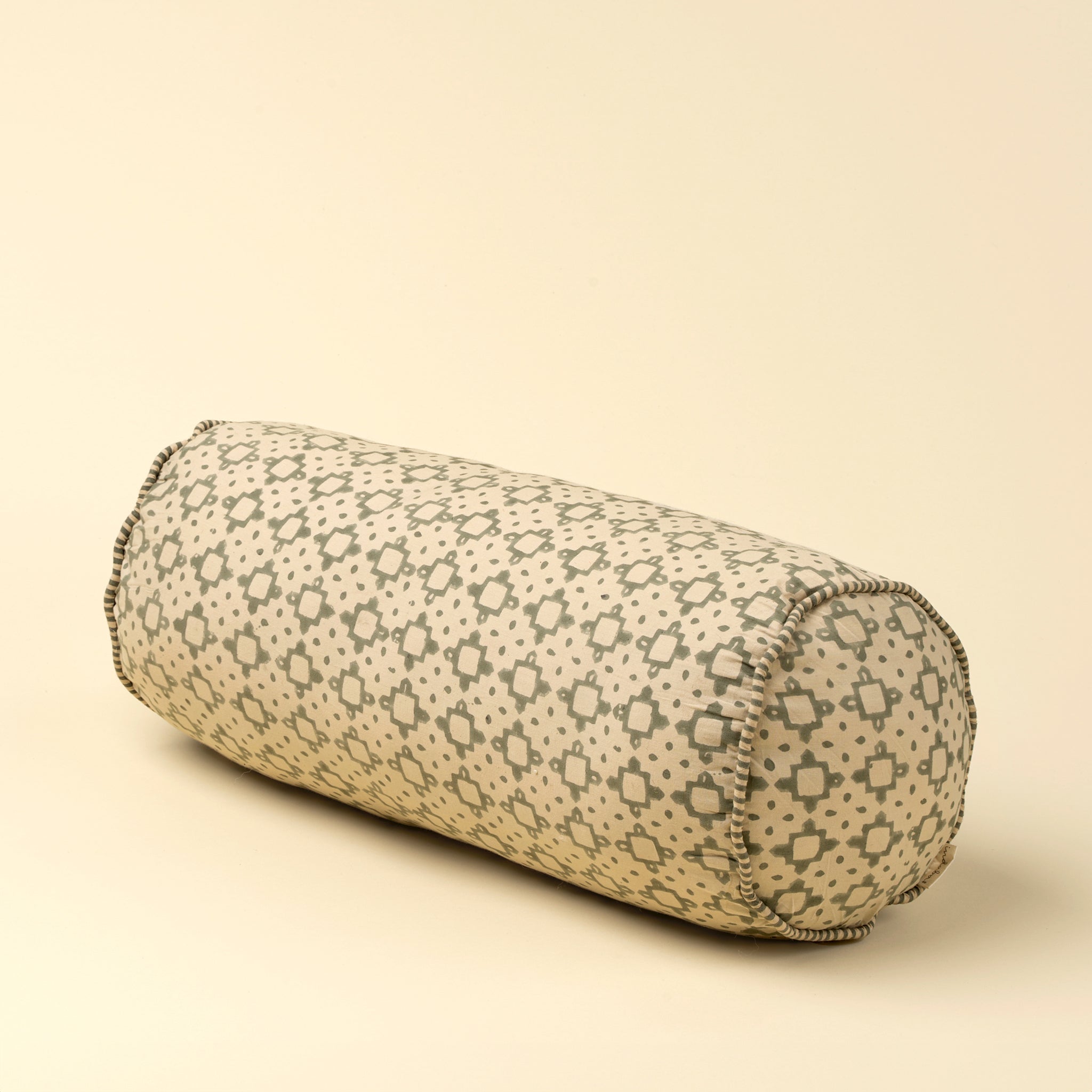  cylindrical pillow with geometric pattern on a beige background