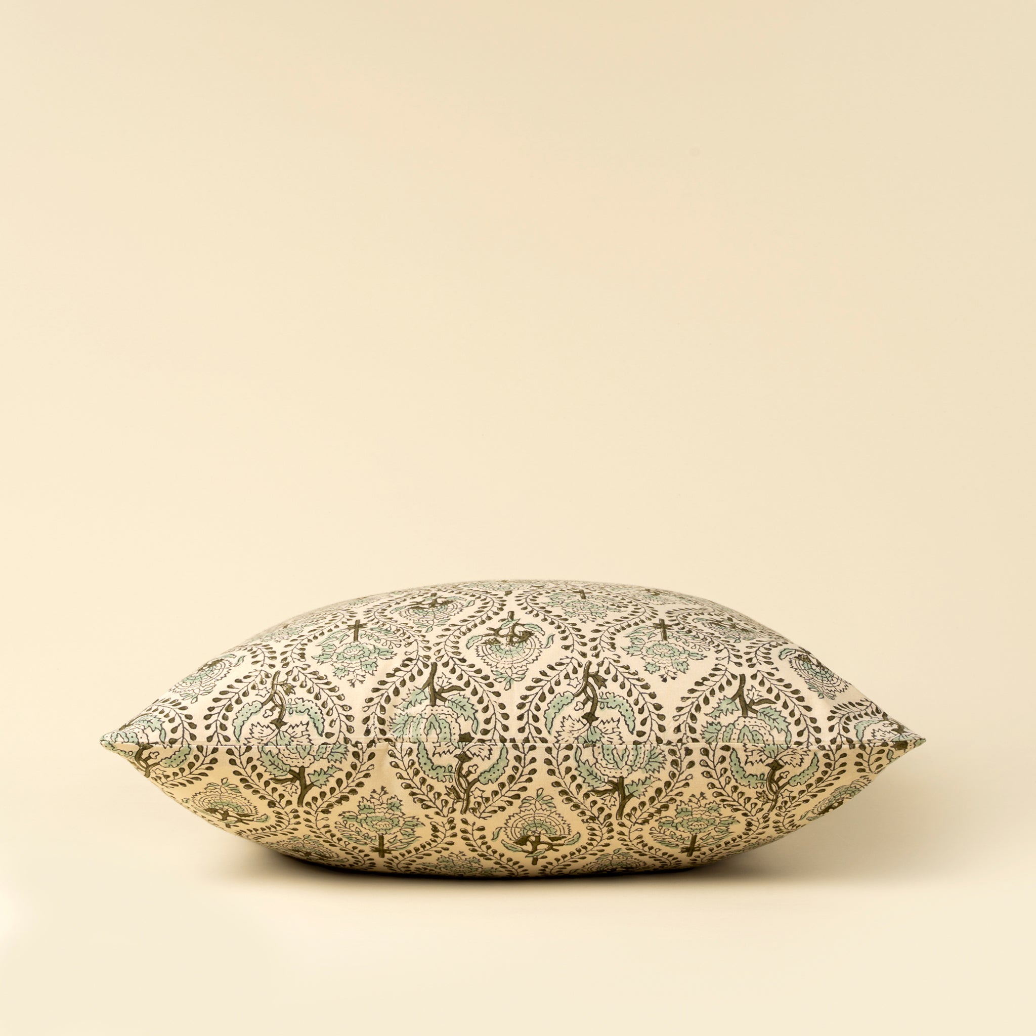 Decorative pillow with intricate pattern on a beige background