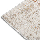 Macro detail of the bound edge and soft, plush pile on the neutral and rust Lennox abstract rug.