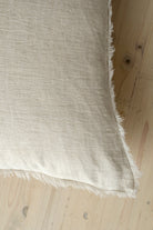 Macro close-up of the Lina linen pillow showcasing the breathable fabric and the delicate frayed fringe edge