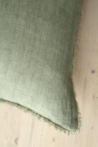 Macro close-up of the Lina linen pillow showcasing the breathable fabric and the delicate frayed fringe edge