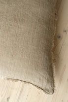 Macro close-up of the Lina linen pillow showcasing the breathable fabric and the delicate frayed fringe edge