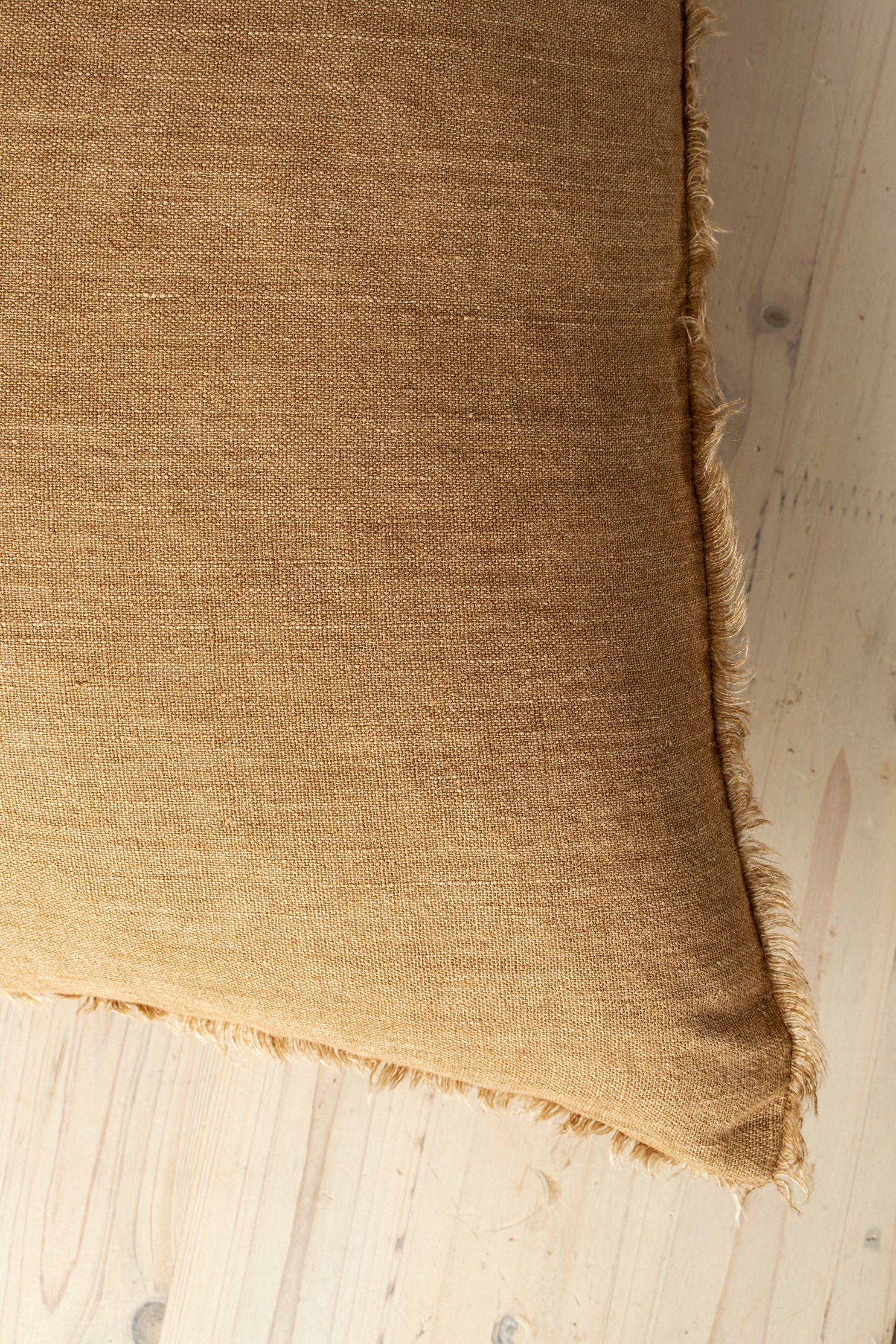 Macro close-up of the Lina linen pillow showcasing the breathable fabric and the delicate frayed fringe edge