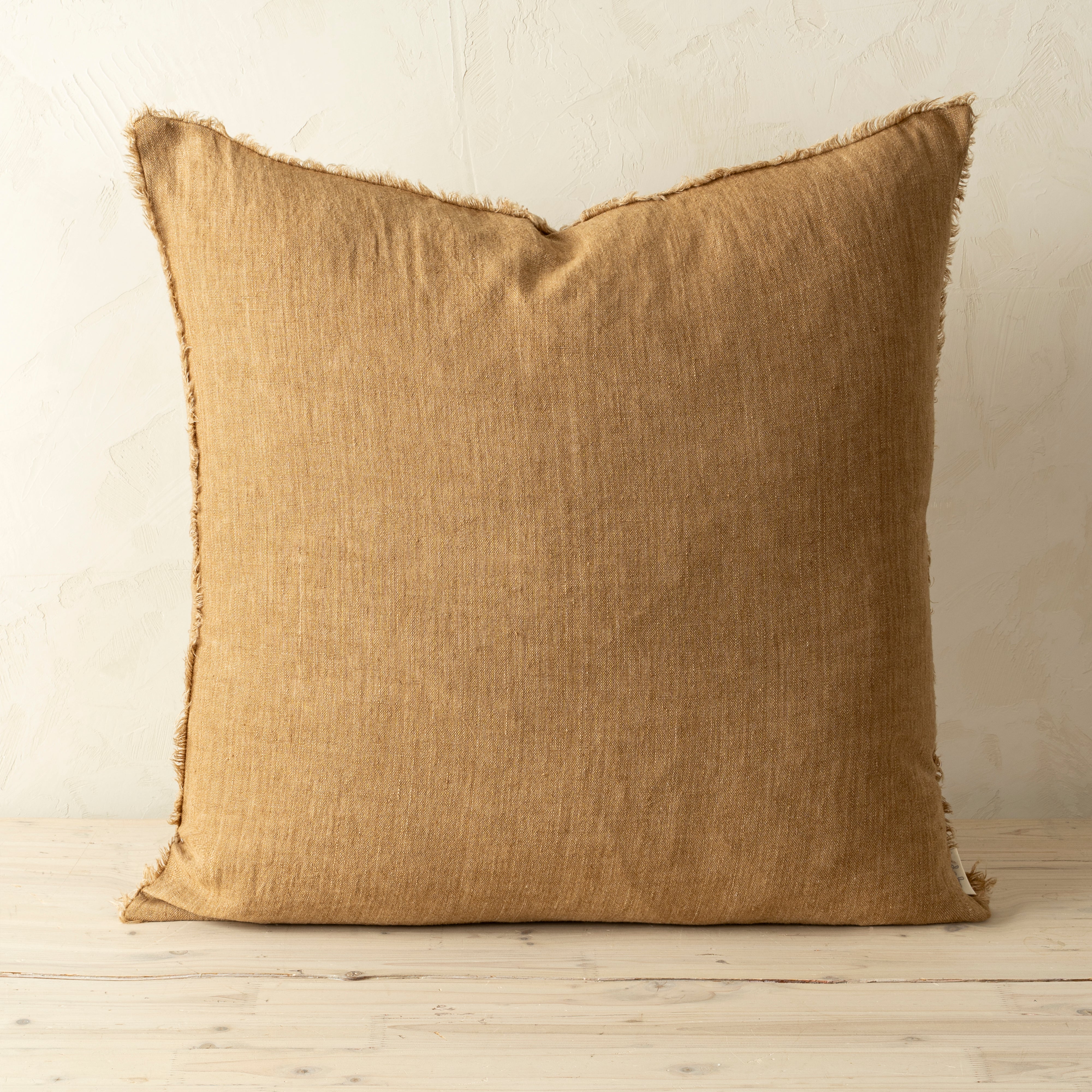 Full front view of the Lina linen pillow featuring a natural raw-edge fringe detail.