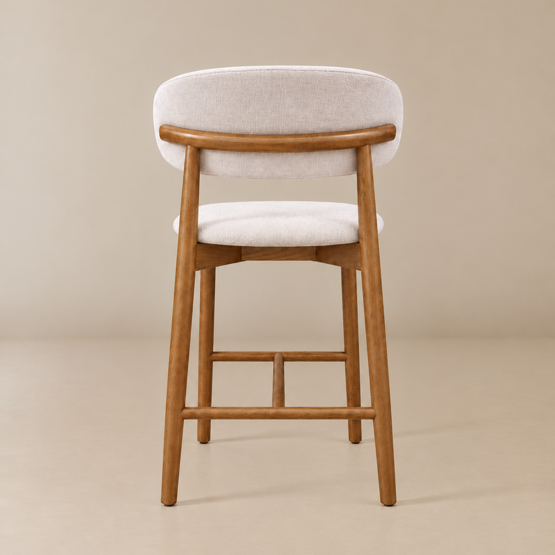 Back view of the Linen Ash Wood 26-inch Counter Stool showing its curved wood back rail, ivory linen upholstery and wood footrest.