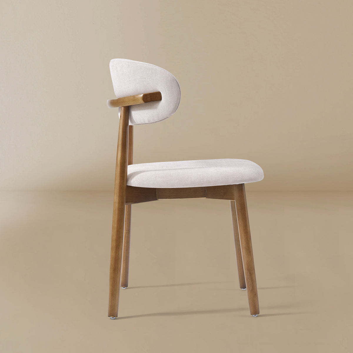 Side profile view of the Linen Ash Wood Dining Side Chairs with curved upholstered backs and ash wood frames, shown in a neutral studio setting