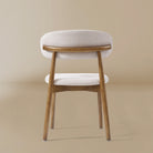 Back profile of the Linen Ash Wood Dining Side Chairs with curved upholstered backs and ash wood frames, shown in a neutral studio setting