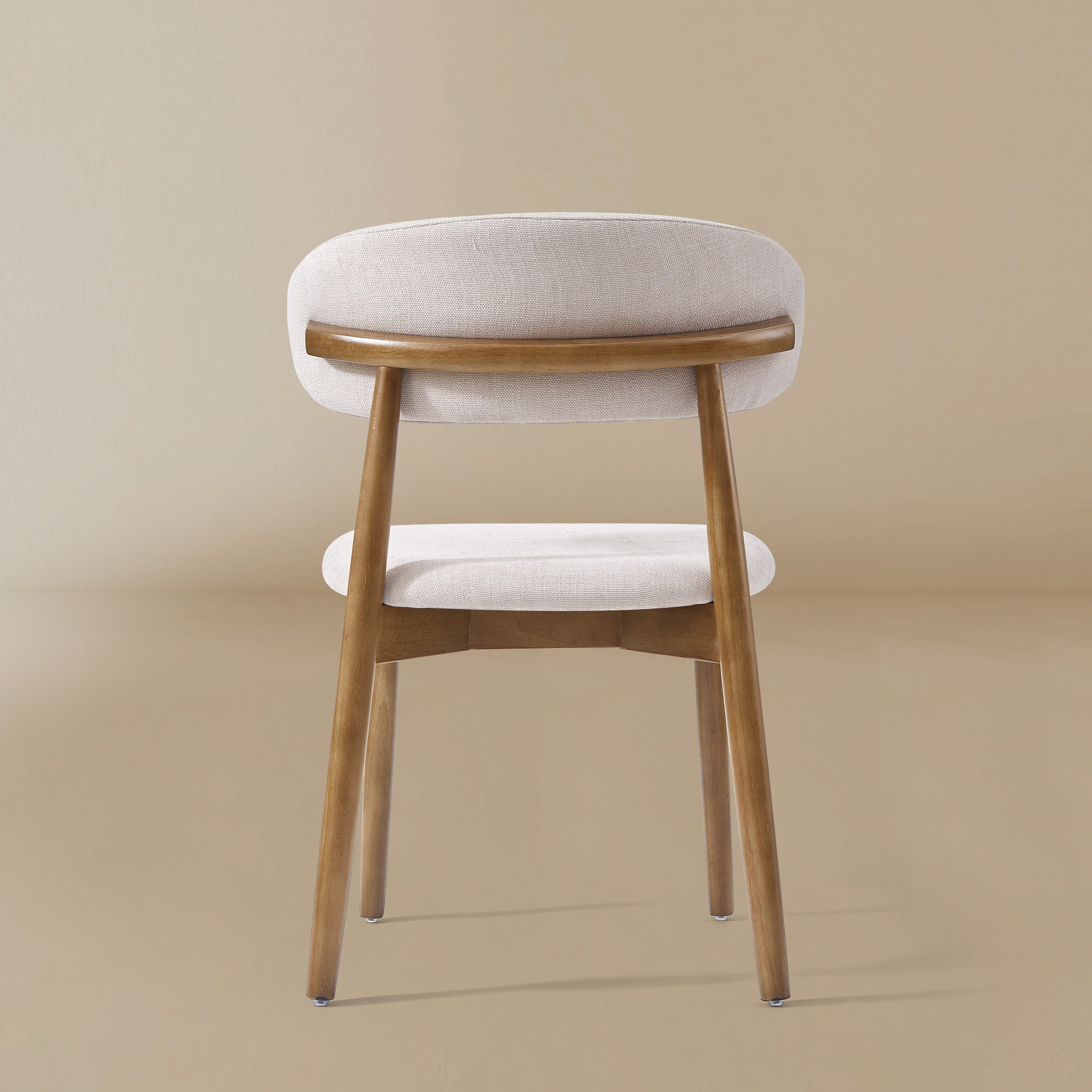 Back profile of the Linen Ash Wood Dining Side Chairs with curved upholstered backs and ash wood frames, shown in a neutral studio setting