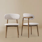 Two Linen Ash Wood Dining Side Chairs with curved upholstered backs and ash wood frames, shown in a neutral studio setting