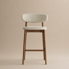 Bar stool with wooden legs and light gray cushioned seat on a beige background