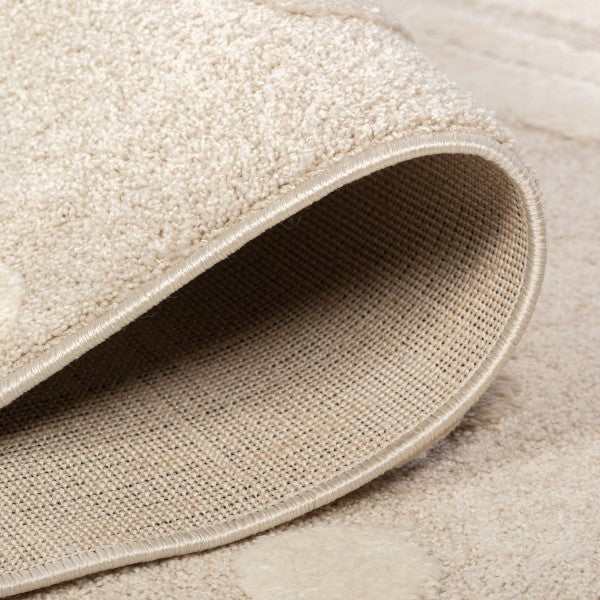 Folded edge of the Little Roar Kids Rug showing its soft pile, bound edge and woven backing.