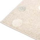 Close-up corner of the Little Roar Kids Rug showing its soft neutral pile and raised dot detail.