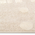 Close-up pile detail of the Little Roar Kids Rug showing soft neutral texture and raised circular accents.