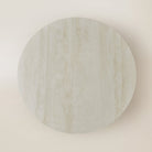 Round white travertine table top on a white background