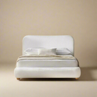 Luma Bouclé Bed in white boucle fabric with rounded frame and soft curved headboard styled in a minimal beige studio setting
