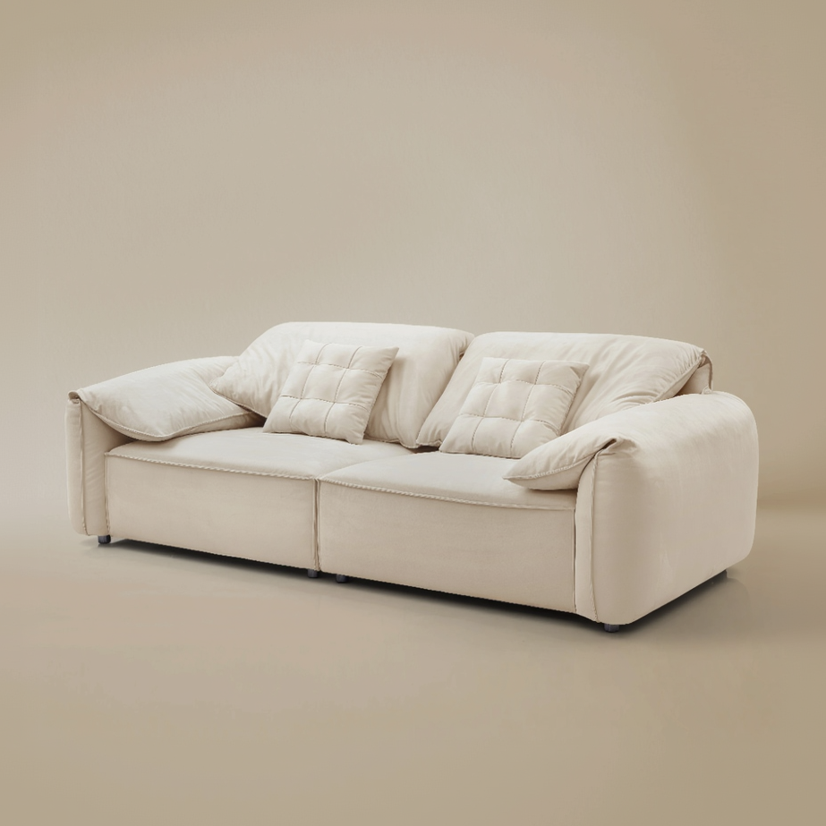 Beige sofa with quilted cushions on a beige background