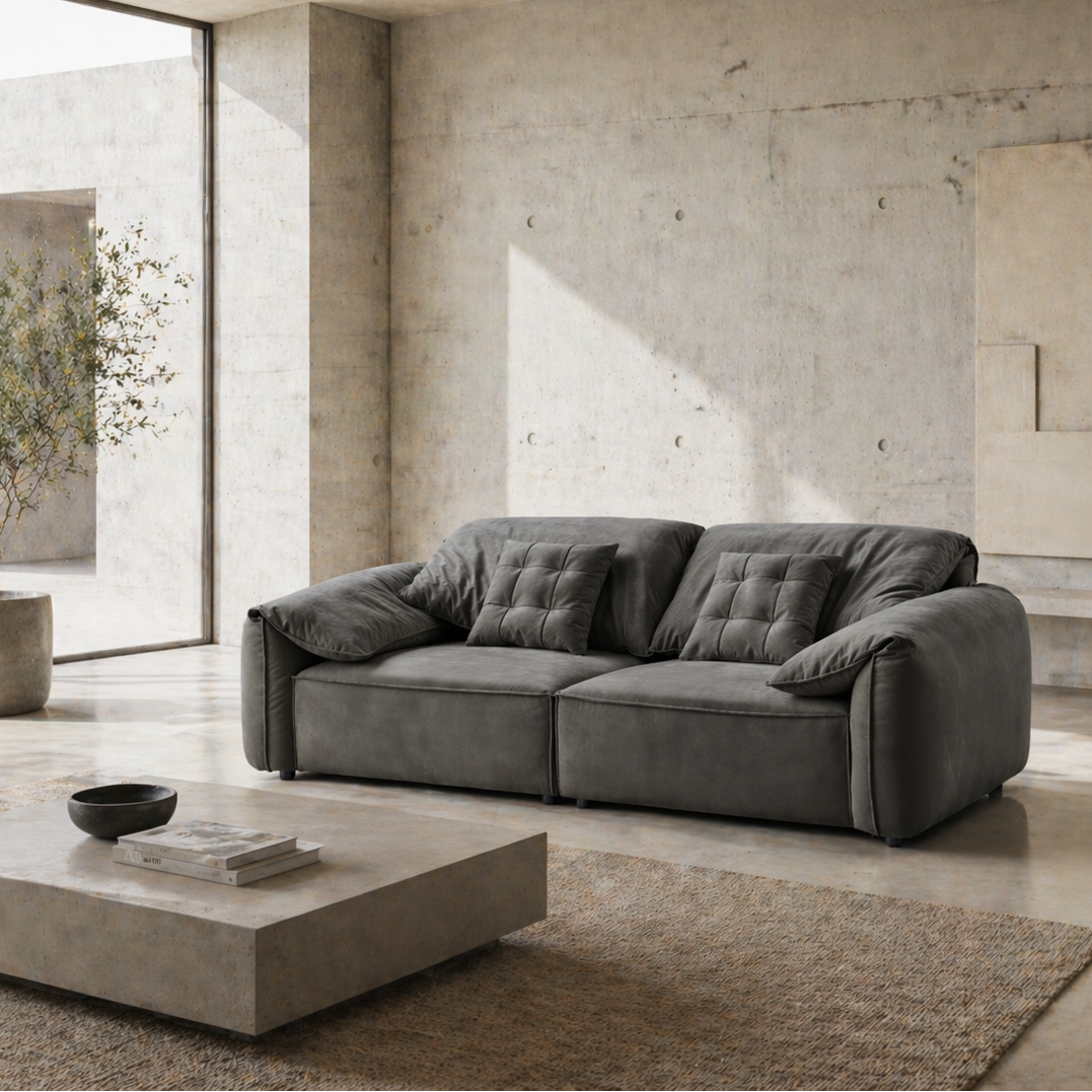 Gray sofa in a modern living room with concrete walls and floor.