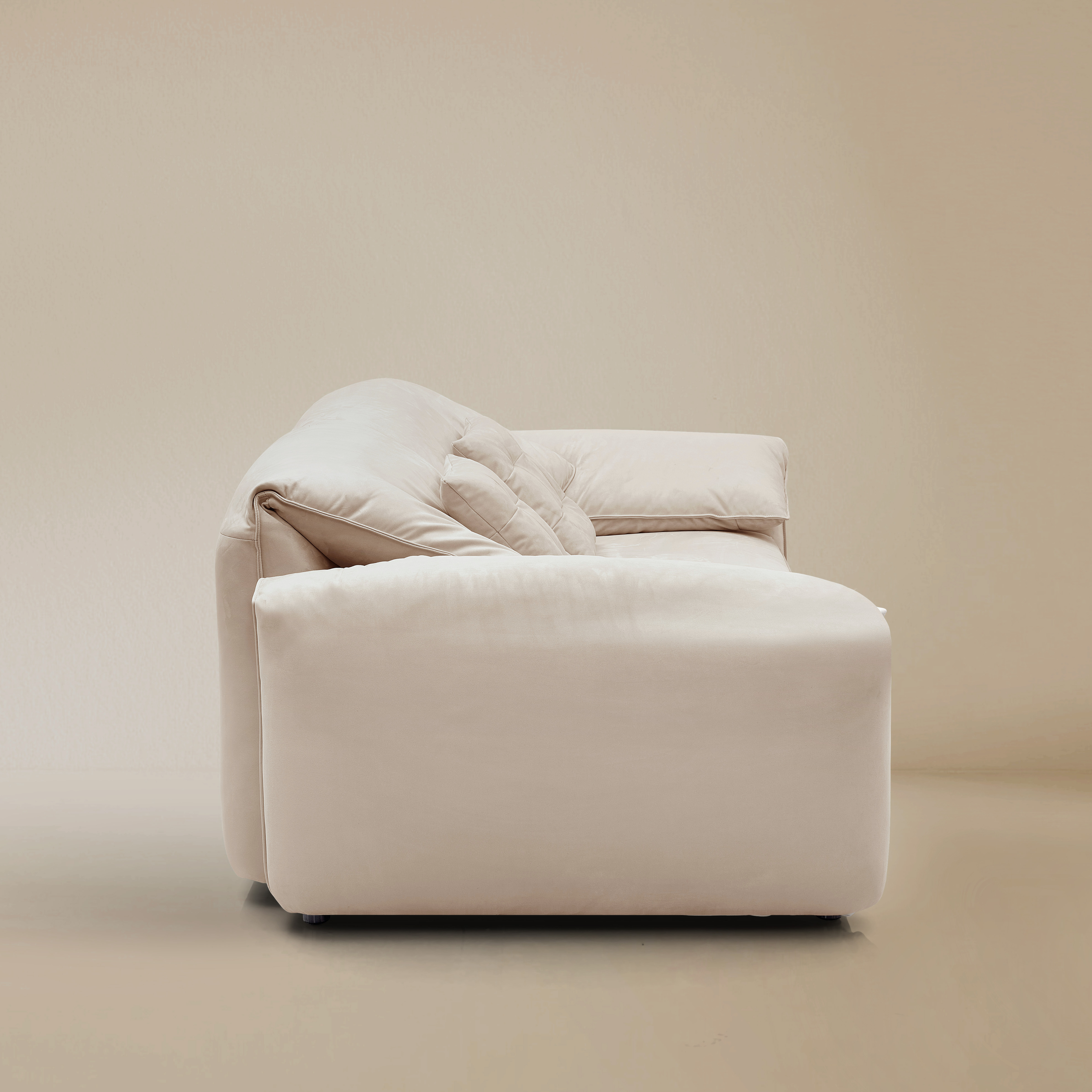 Beige sofa with quilted cushions on a beige background