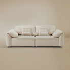 Beige sofa with quilted cushions on a beige background