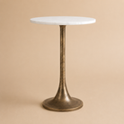 Round table with marble top and bronze base on a beige background