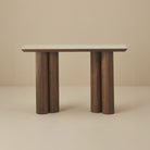 Front view of the Lyric Console table with wooden legs and a travertine sintered stone top on a beige background
