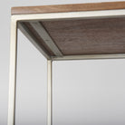 Close-up view of the underside of a wooden shelf and the supporting metal frame construction on the Maddox shelving unit.