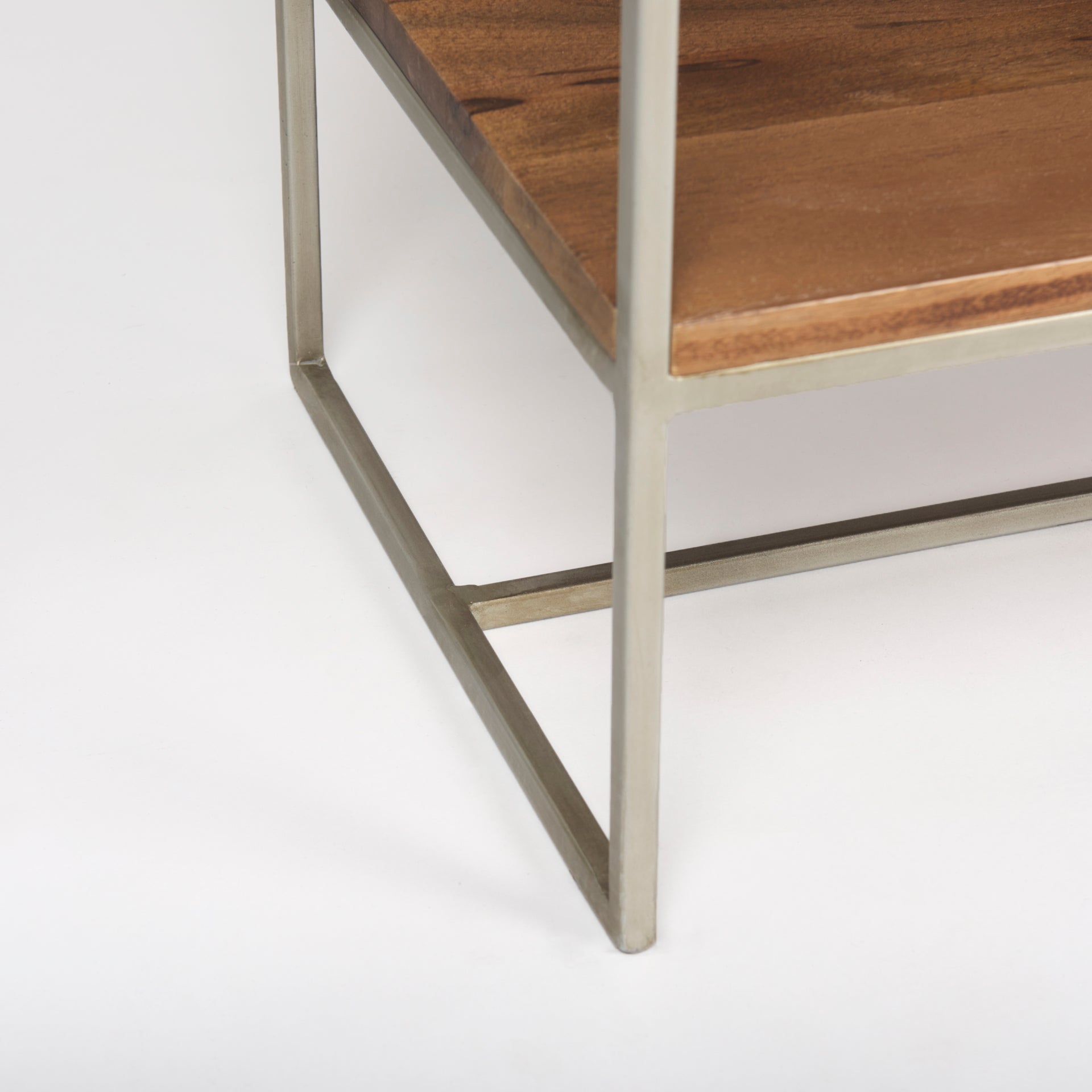 Close-up of the bottom corner showing the silver metal frame and wooden base of the Maddox shelving unit.