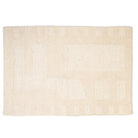 Full top-down view of the Maeve hand-woven wool rug in ivory, featuring a tonal abstract geometric pattern with textured block shapes.