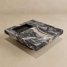 Marble-patterned coffee table with decorative items on a beige background