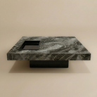 Marble-patterned coffee table with a square hole on a beige background