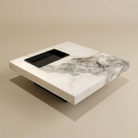 Marble-patterned coffee table with a black tray on a beige background
